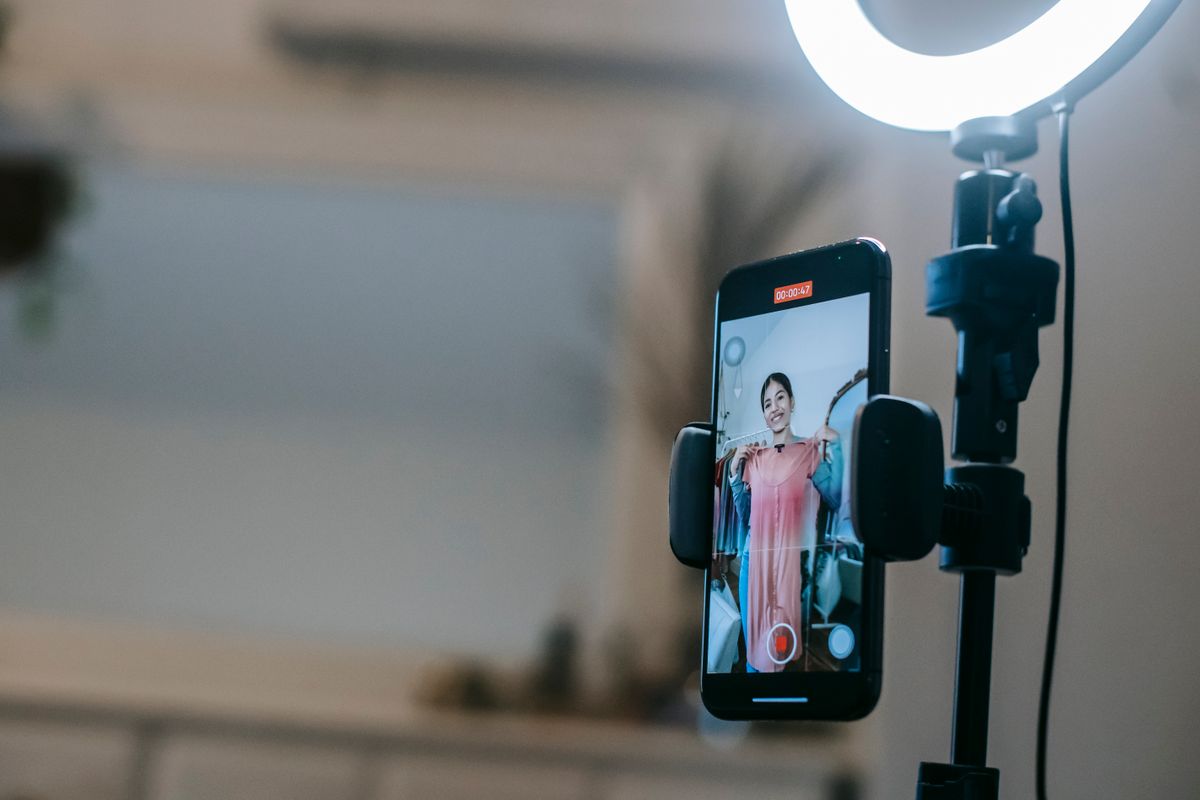 Kreatorica pozira ispred ring lighta s telefonom postavljenim u sredini