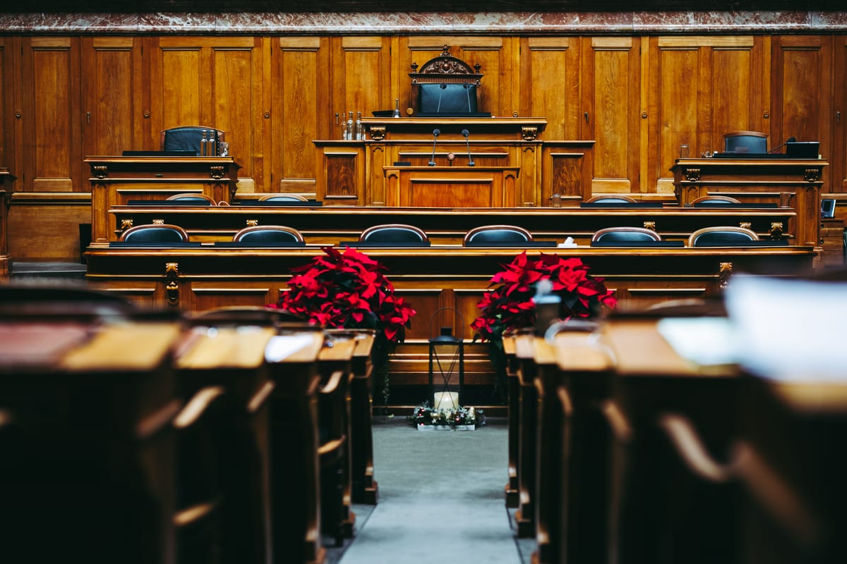 Unutrašnjost prazne sudnice s drvenom oplatom i redovima klupa